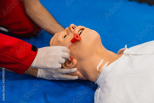Medical manipulation for airway management. Nasopharyngeal tube airway insertion by stuff in a black gloves on a simulation mannequin dummy during medical training. ACLS photo