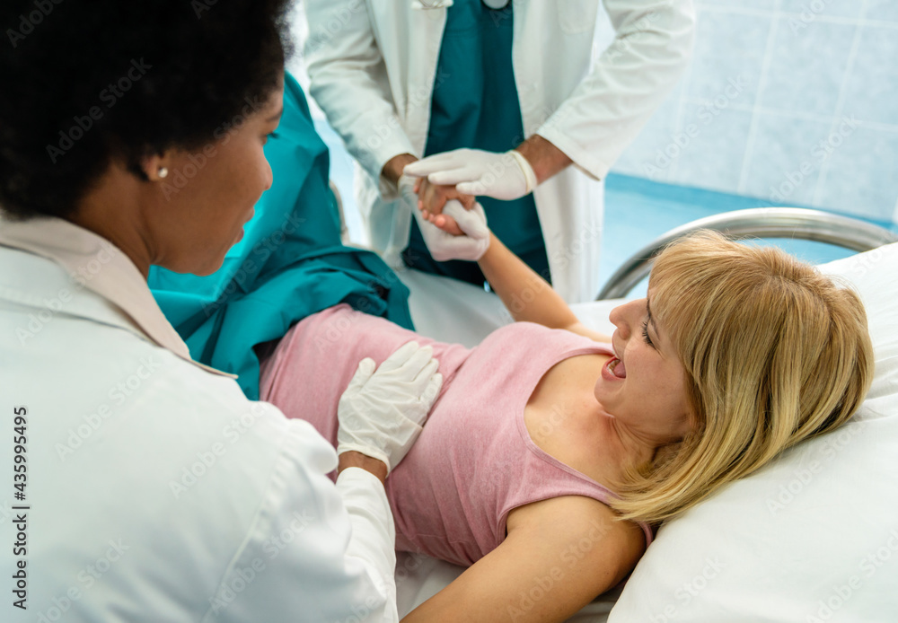 Obraz premium Woman giving birth in hospital with medical doctor team