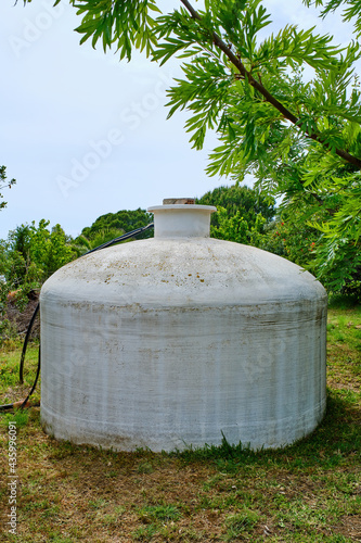 Fotografia Large fiberglass cistern located in a garden surrounded by grass and plants