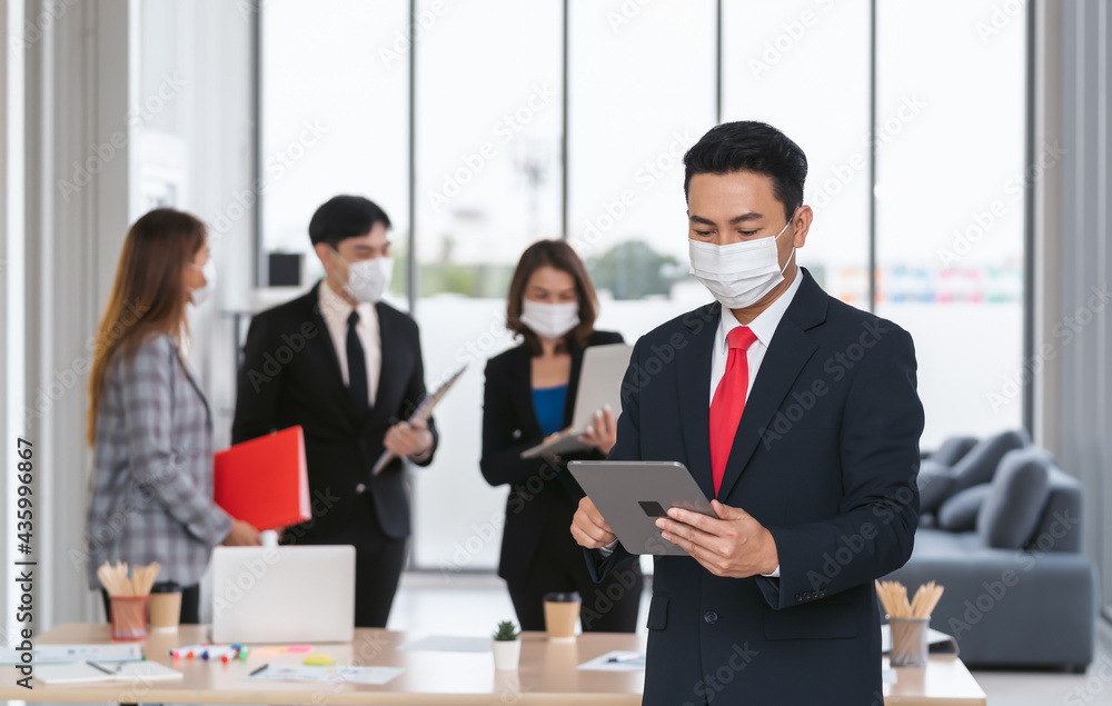 businessman standing with holding mobile in office businessman standing with holding mobile in office