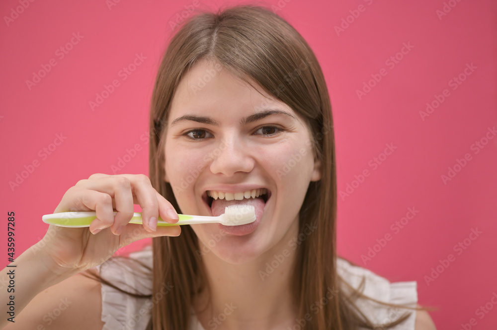 Young Woman Cleaning Tongue Using Toothbrush Young Woman Cleaning Tongue Using Toothbrush