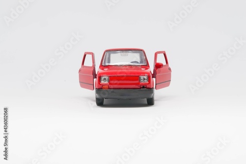 Maluch samochód zabawka koloru czerwonego stojący przodem z otwartmi drzwiami
