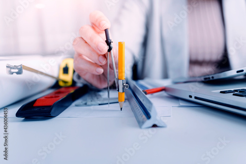 engineer working at a drawings of house in office for discussing. Engineering tools and construction concept.