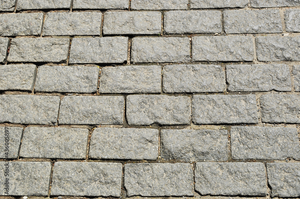 Paving stones from rectangular granite stones. Background, texture. design. A fragment of the sidewalk.