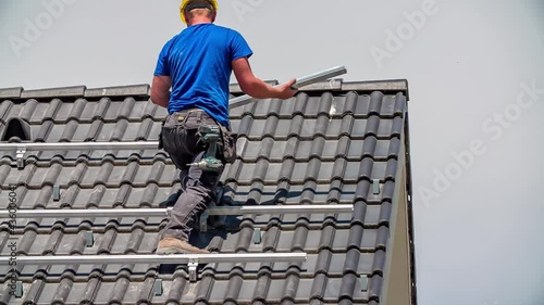 Wallpaper Mural Caucasian Technician drilling construction for solar panels on rooftop,slowmotion Torontodigital.ca