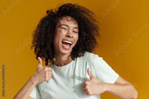 Young african woman laughing while showing thumbs up