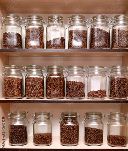 Glass jars with coffee beans on rack
