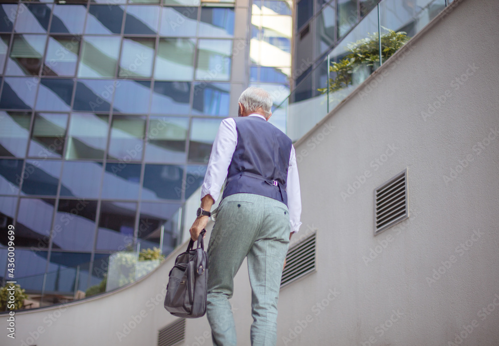 Senior business man walking trough street.