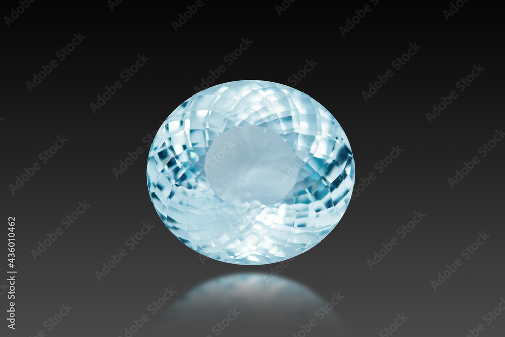 Oval faceted loose aquamarine natural light blue color gemstone setting used for makin jewelry. Front view, blur bottom semireflection on dark, black background. Gemology theme. Beryl group mineral. Oval faceted loose aquamarine natural light blue color gemstone setting used for makin jewelry. Front view, blur bottom semireflection on dark, black background. Gemology theme. Beryl group mineral.