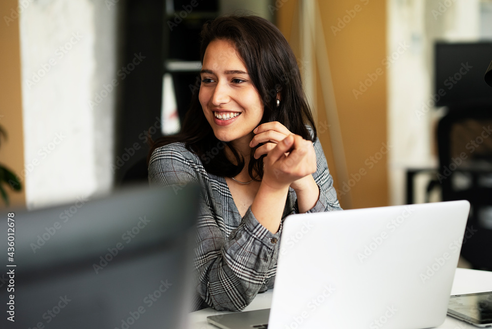 Happy businesswoman working on laptop. Portrait of beautiful businesswoman in the office Happy businesswoman working on laptop. Portrait of beautiful businesswoman in the office