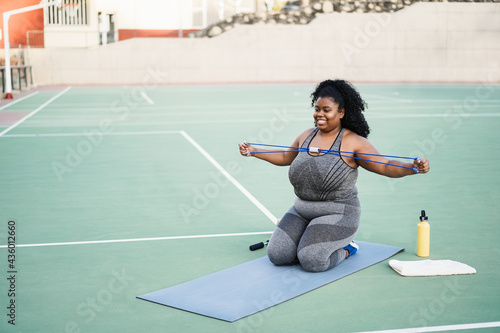 Plus size woman doing workout routine outdoor at city park - Focus on face