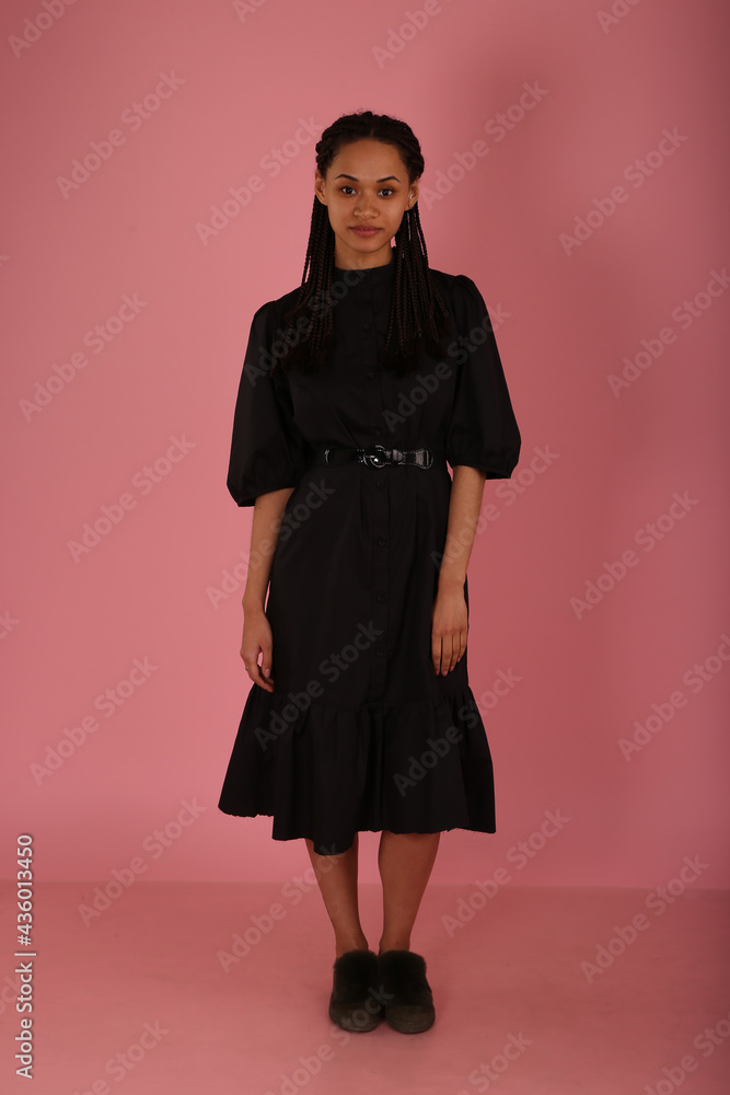 Curly woman in black dress on pink background Curly woman in black dress on pink background
