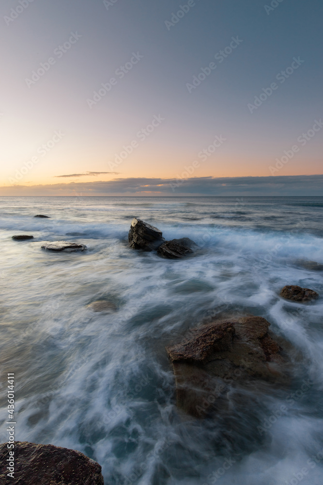 Ocean water flowing between rocks on the coast.