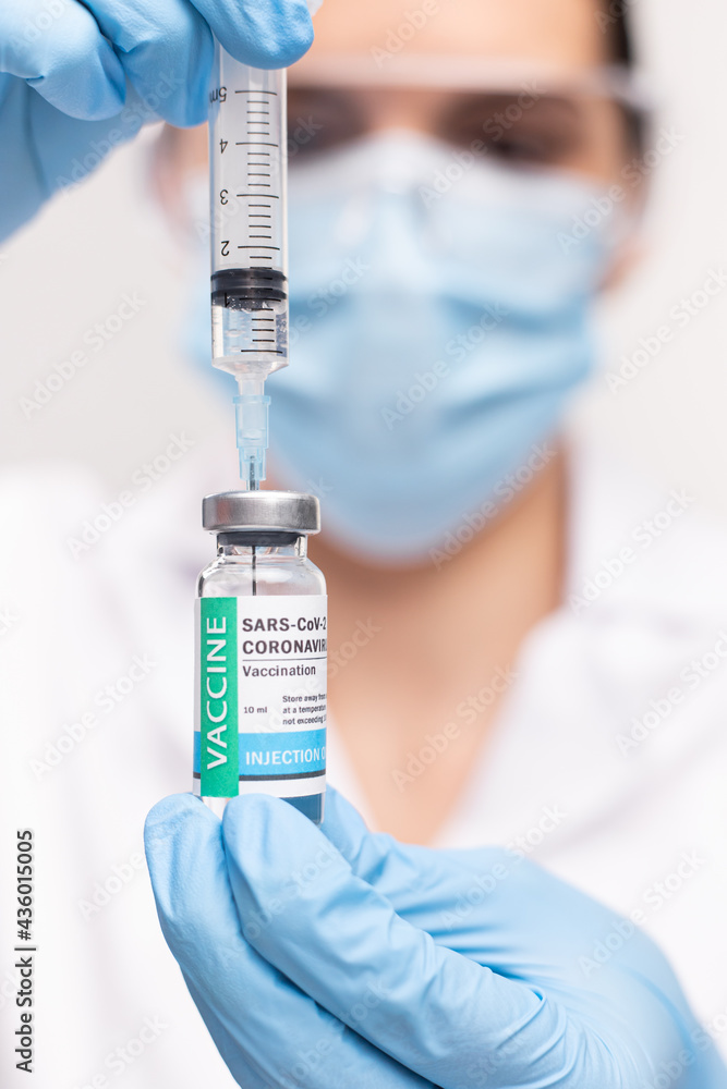 SARS - CoV2 Vaccination concept. Close up COVID-19 vaccine dose. A doctor or nurse in a laboratory holds a vial with a vaccine. Pandemic immunity. SARS - CoV2 Vaccination concept. Close up COVID-19 vaccine dose. A doctor or nurse in a laboratory holds a vial with a vaccine. Pandemic immunity.
