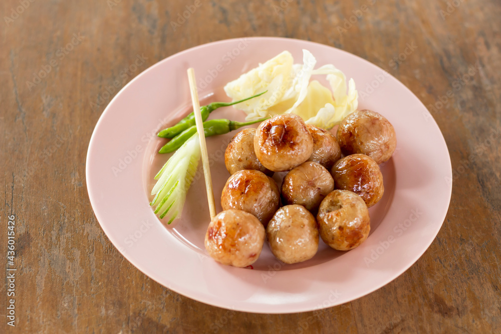 Close up oriental sausage on a pink plate ready to eat Thai food.