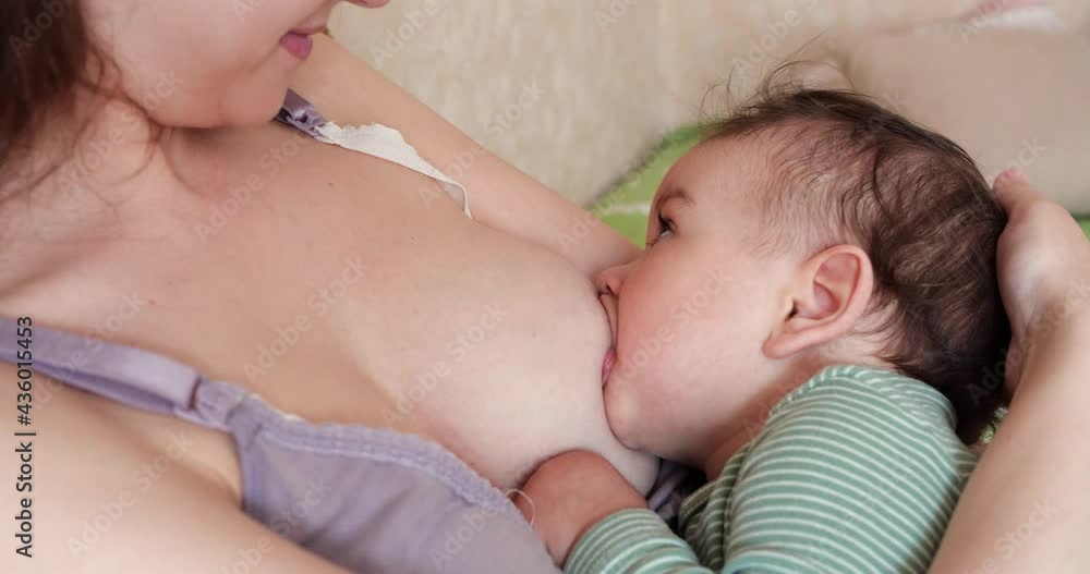 Woman breastfeeding newborn baby. Baby eating mother's milk. Concept of lactation infant Woman breastfeeding newborn baby. Baby eating mother's milk. Concept of lactation infant