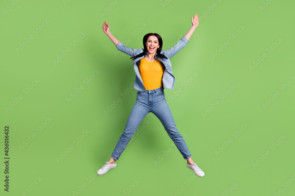 Full size photo of funny nice brown hairdo lady jump wear jeans shirt isolated on pastel green color background