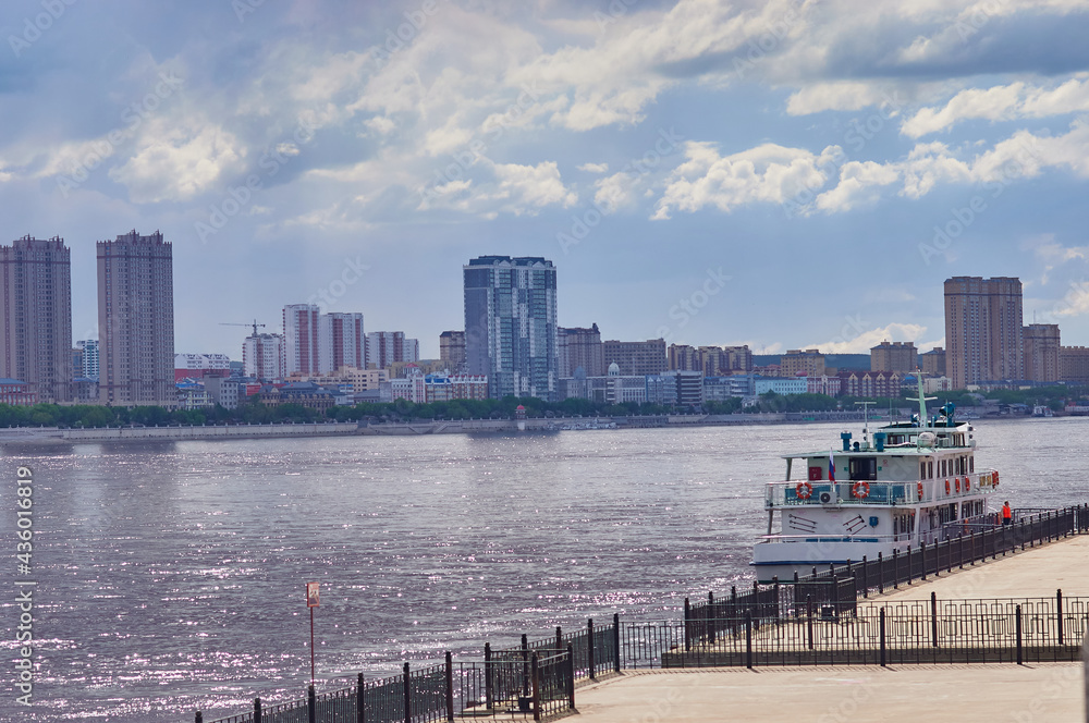 Pleasure boat on the pier of the embankment of Blagoveshchensk. Across the Amur River, the city of Heihe. Pleasure boat on the pier of the embankment of Blagoveshchensk. Across the Amur River, the city of Heihe.