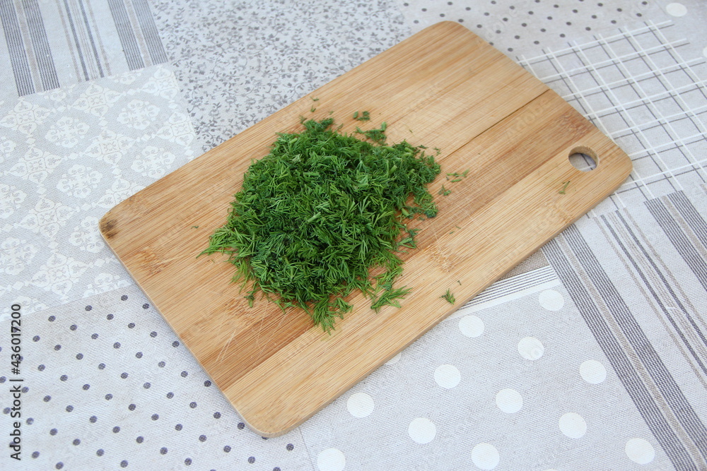 Chopped dill on the wooden cutting board