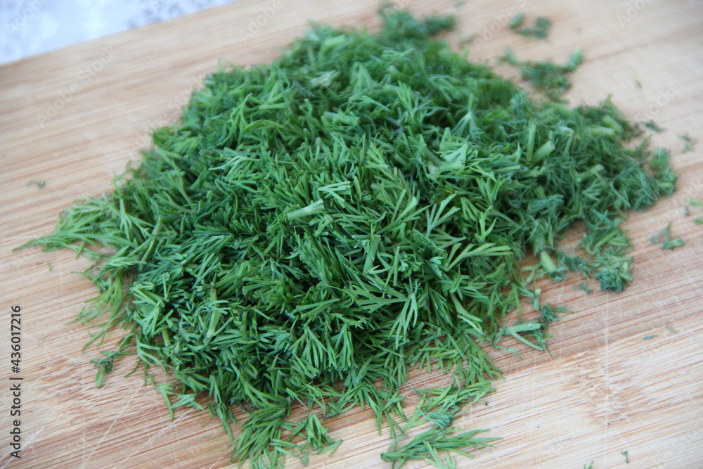 Chopped dill on the wooden cutting board, close-up Chopped dill on the wooden cutting board, close-up