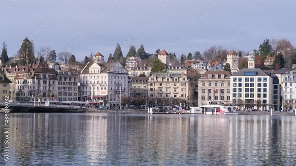 LUCERNE, SWITZERLAND - January 2021: blue surface of Lake Lucerne, transport rides across the bridge, seagulls fly, magnificent Swiss mountains on the far shore, European tourism concept LUCERNE, SWITZERLAND - January 2021: blue surface of Lake Lucerne, transport rides across the bridge, seagulls fly, magnificent Swiss mountains on the far shore, European tourism concept