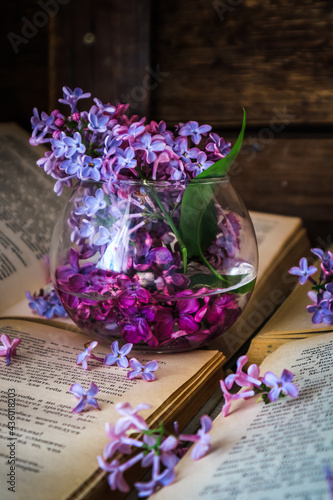 a bouquet of lilacs and a white cup of tea on a wooden background