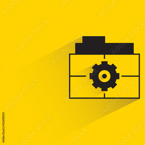 file folder and gear on yellow background