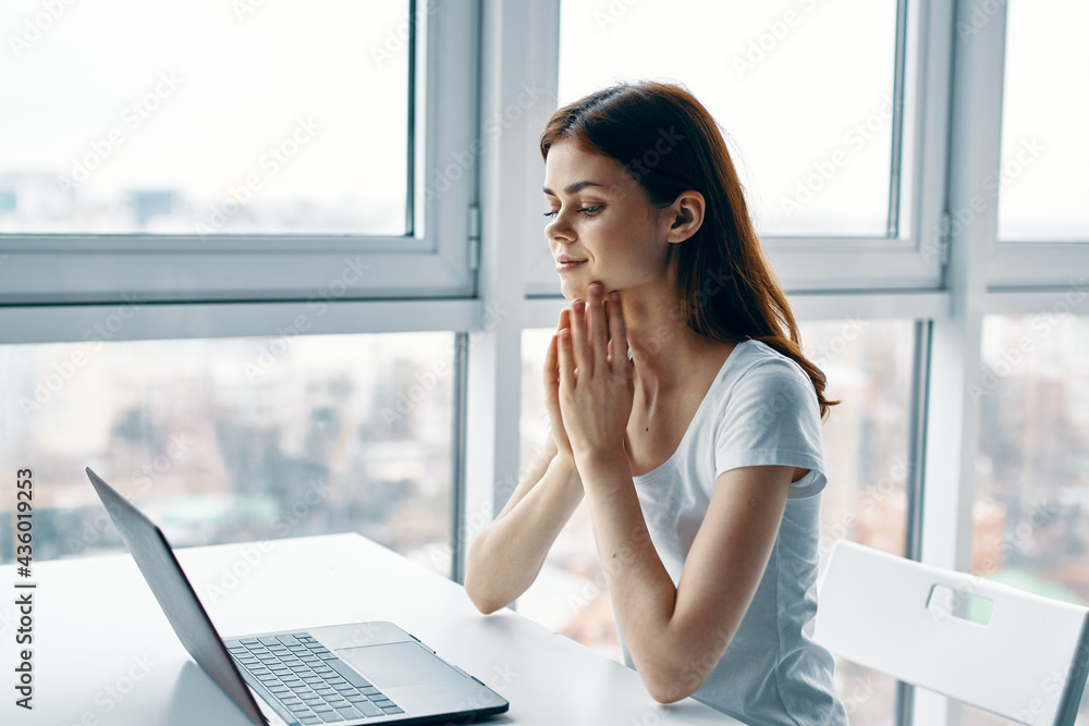 woman at home at the table in front of laptop working office