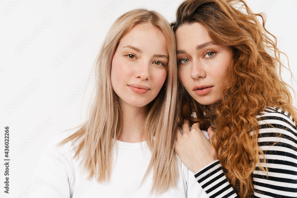 Young white two women hugging while looking at camera Young white two women hugging while looking at camera