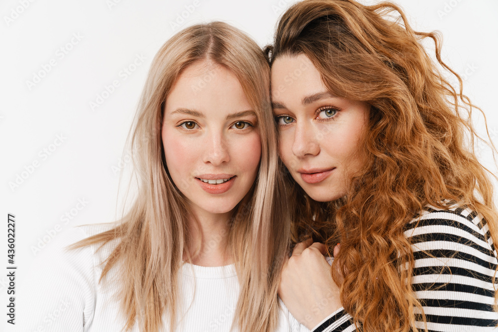 Young white two women hugging while looking at camera Young white two women hugging while looking at camera