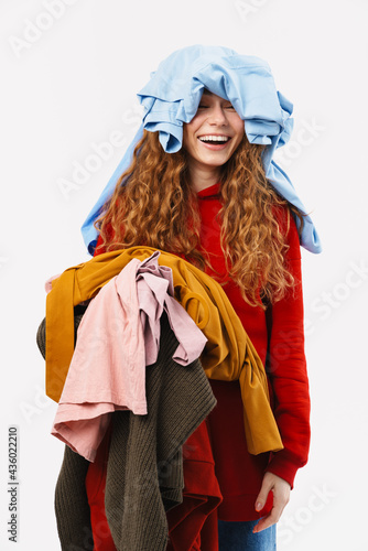 Young ginger woman laughing while posing with clothes