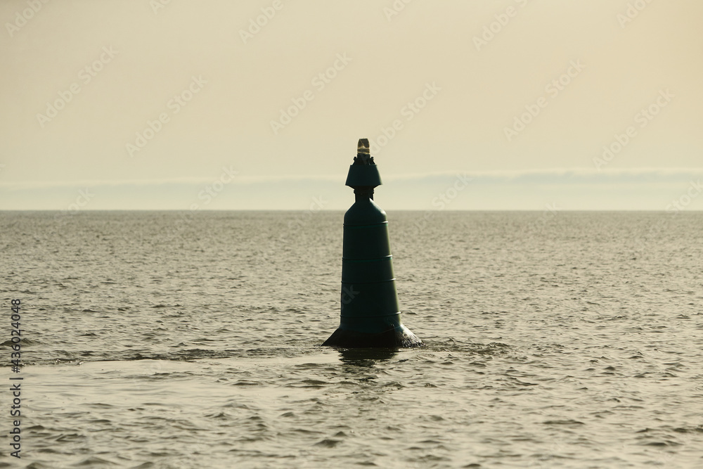 A marker buoy floating in the sea. beacon. Sunny afternoon. 