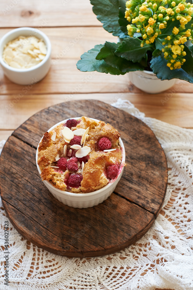 Fototapeta premium Bread pudding with raspberry. Side view, wooden background.
