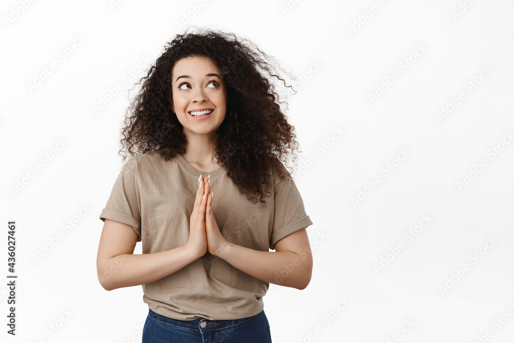 Thoughtful young woman thinking of something nice, steeple fingers while pondering, make a plan, deciding what to do and smiling, looking at upper right corner, white background Thoughtful young woman thinking of something nice, steeple fingers while pondering, make a plan, deciding what to do and smiling, looking at upper right corner, white background