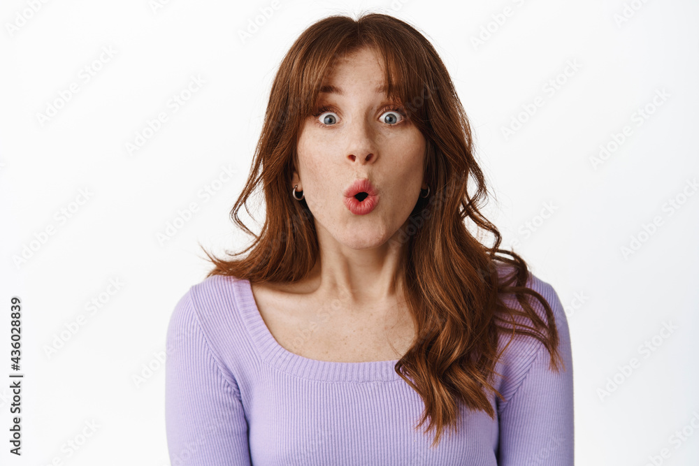 Surprised and excited girl spot great deal in store, staring astonished and amused at camera, say wow, gasping impressed at advertisement, standing in purple blouse against white background Surprised and excited girl spot great deal in store, staring astonished and amused at camera, say wow, gasping impressed at advertisement, standing in purple blouse against white background