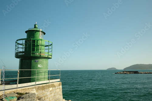 Lighthouse on the dike of the port of La Spezia. A green lighthouse marks the entrance to the port near the Cinque Terre. 