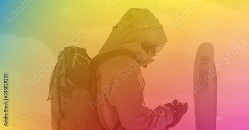 Composition of skier with skis in mountains with rainbow tint