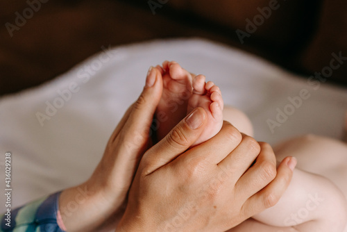 Baby feet in mother hands. Tiny Newborn Baby's teeny little feet closeup. Mom and her Child. Happy Family concept. Beautiful conceptual image of Maternity