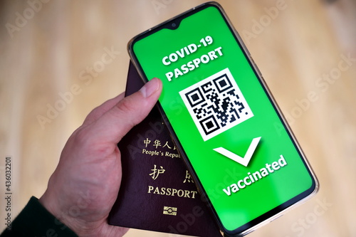 Traveling during SARS-CoV-19 pandemic. Traditional passport and Covid-19 passport application in mobile phone.