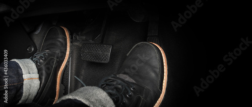 Foot pressing foot pedal of a car to drive. Accelerator and brake pedal in a car. Driver driving the car by pushing accelerator and break pedals of the car. inside vehicle. control pedal. Close up.