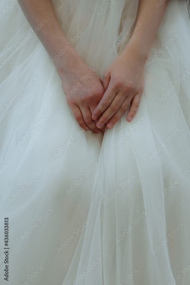 Baby hands on a background of airy white organza material Baby hands on a background of airy white organza material
