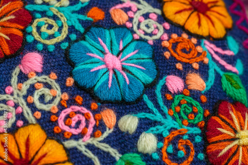 Peruvian crafts: Embroidered flower ornaments on a handmade fabric photo
