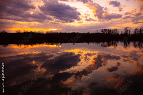Purple sky clouds with lake reflections at sunset in Michigan, USA. © Thomas