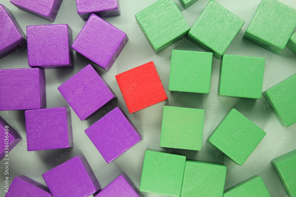 the concept of green and purple wooden cubes with one red cube in the middle the concept of green and purple wooden cubes with one red cube in the middle