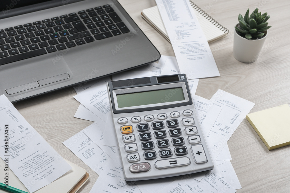 Man hand using calculator and writing make note with calculate about cost and taxes at home office. Businessman doing some paperwork in the workplace Man hand using calculator and writing make note with calculate about cost and taxes at home office. Businessman doing some paperwork in the workplace