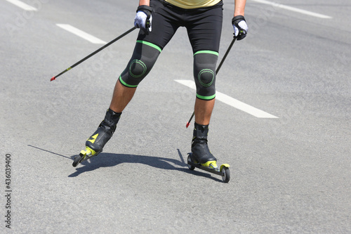 athlete is roller skiing on the asphalt on the road