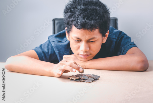 Save money concept, teenager boy  hands hold putting coins concept, young boy looking coins conceptual  save money for future,  design idea saving money with background.