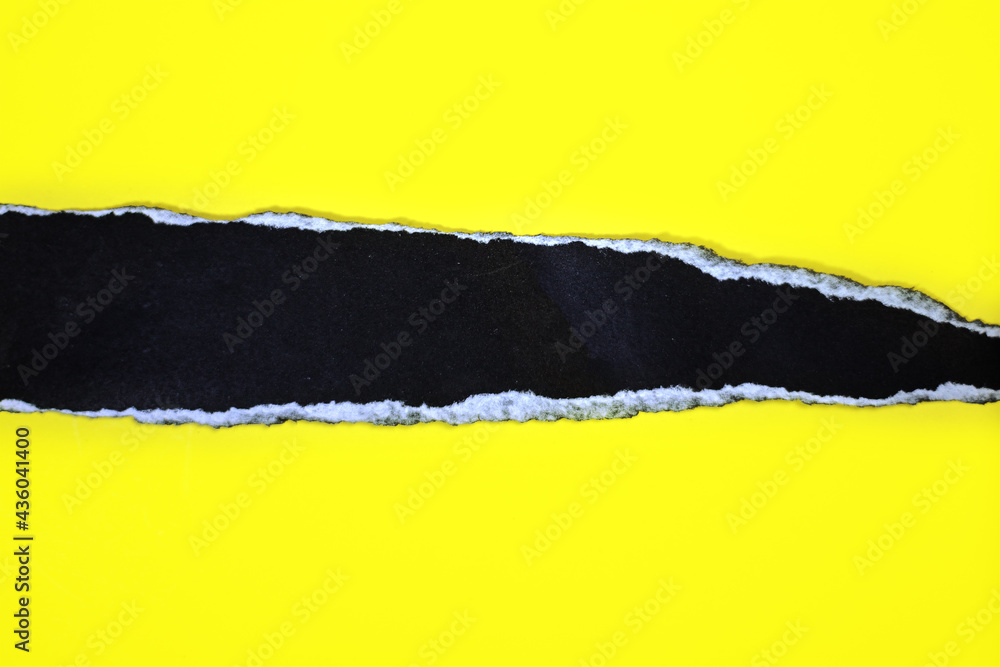 Obraz premium Black torn paper with torn marks on yellow background. top view photo with copy space and text area