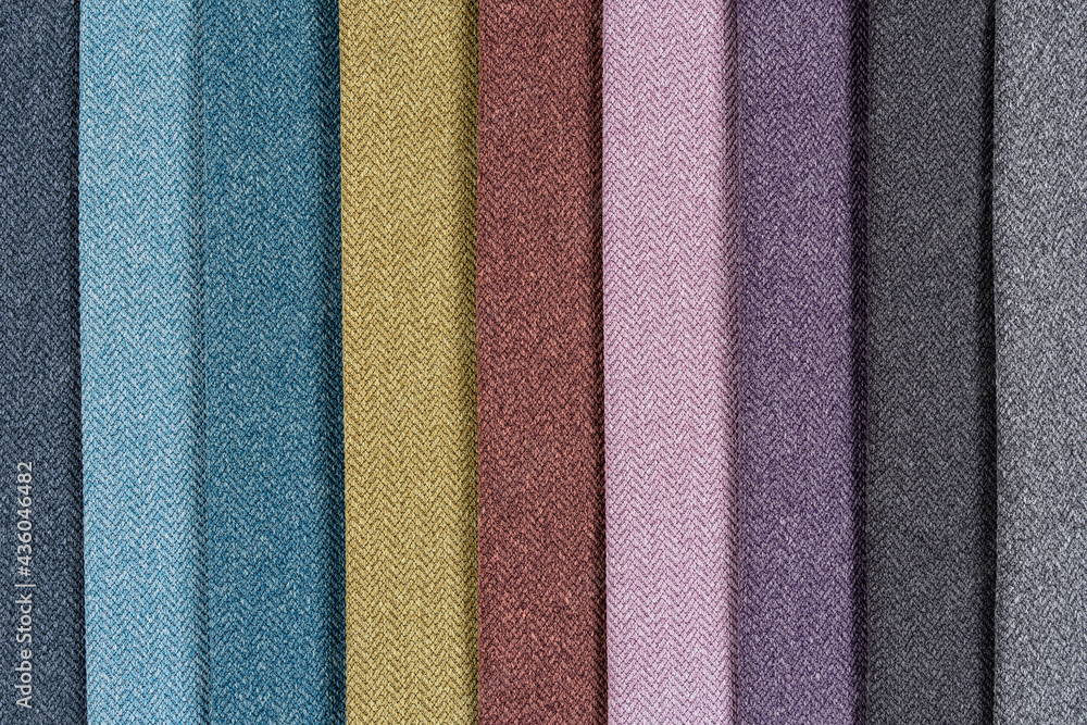 Fototapeta premium Multi-colored samples of woven textiles. Catalog and palette tone of Interior fabric for furniture, closeup.