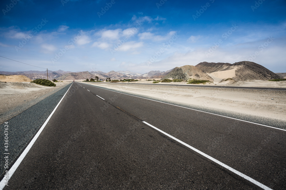 The black asphalt of the Pan-American Highway, crossing the desert north of Peru
